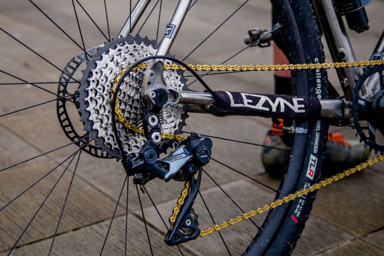 Ultegra RX clutch mech, 11-42 cassette and gold chain on the Tripster V3, beside a Challenge Gravel Grinder tyre.