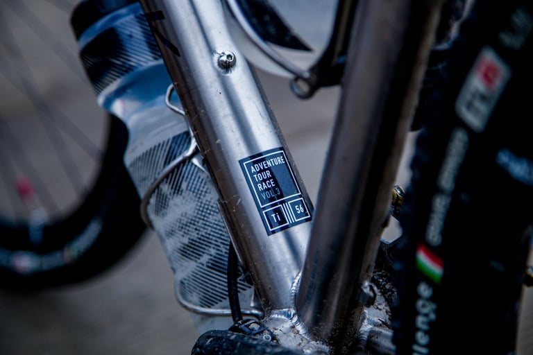 Laser-etched Adventure Tour Race Vol. 3 decal on the Kinesis Tripster ATR V3 downtube, size 56 in titanium.
