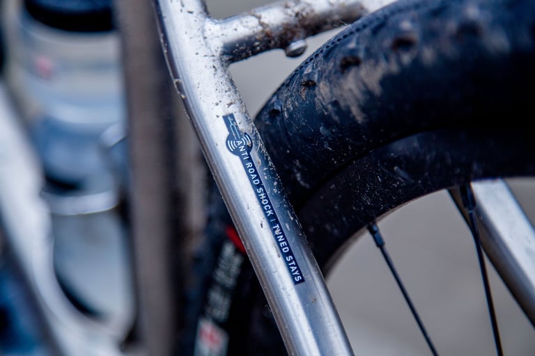 Anti Road Shock tuned stays decal on the revised seat stay of the Kinesis Tripster ATR V3, above a muddy tyre.