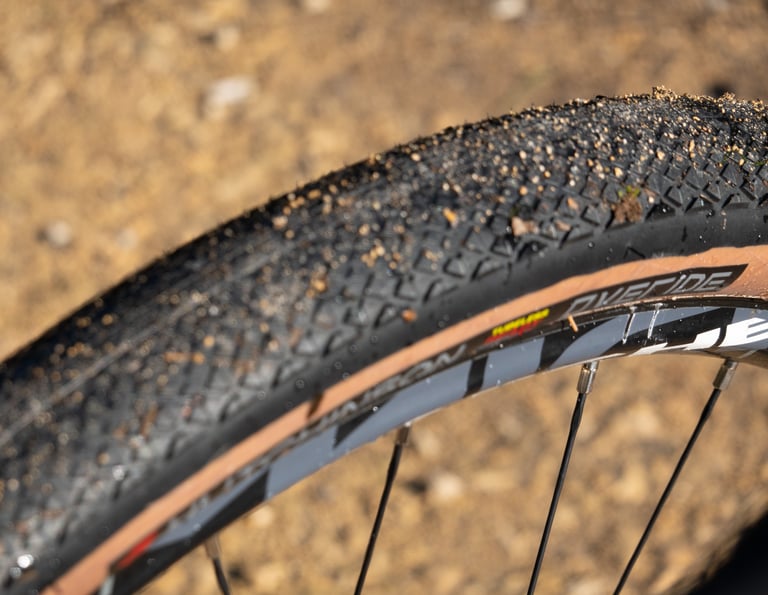 Close-up of the Hutchinson Overide's fine diamond tread, flecked with grit, above the tan sidewall.