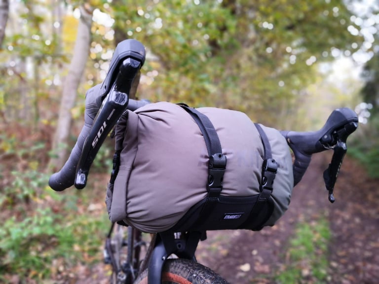 Dry bag strapped into the Straight Cut Design harness with two quick-release buckles, seen from the front of the bike.