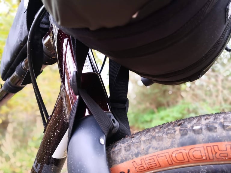 Underside view of the Straight Cut Design harness straps at the fork crown, clear of the tyre and frame paint.