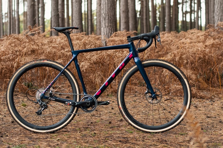 Side view of the custom Vitus Energie Evo CX Syndicate Edition in navy with pink graphics and tan-wall tyres.
