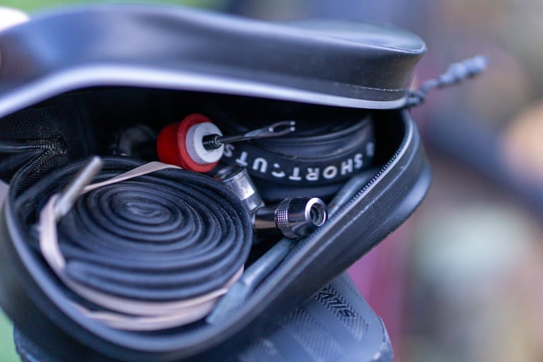 Open Arundel Gordo saddle bag holding a rolled inner tube, a tyre lever and small tools.