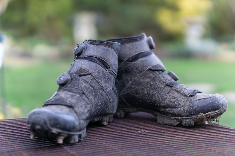 Lake MX145 winter boots caked in mud, showing the waxed canvas and suede-style uppers.
