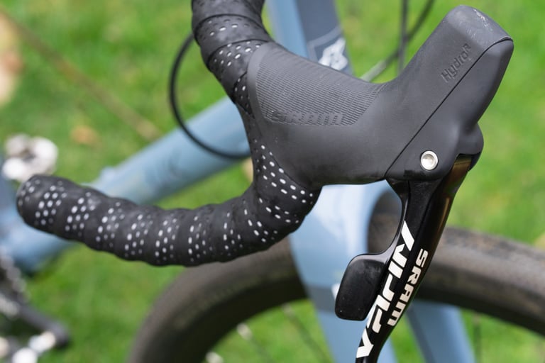 SRAM Apex hydraulic brake lever and flared-drop handlebar with dotted black bar tape on the Kinesis G2.