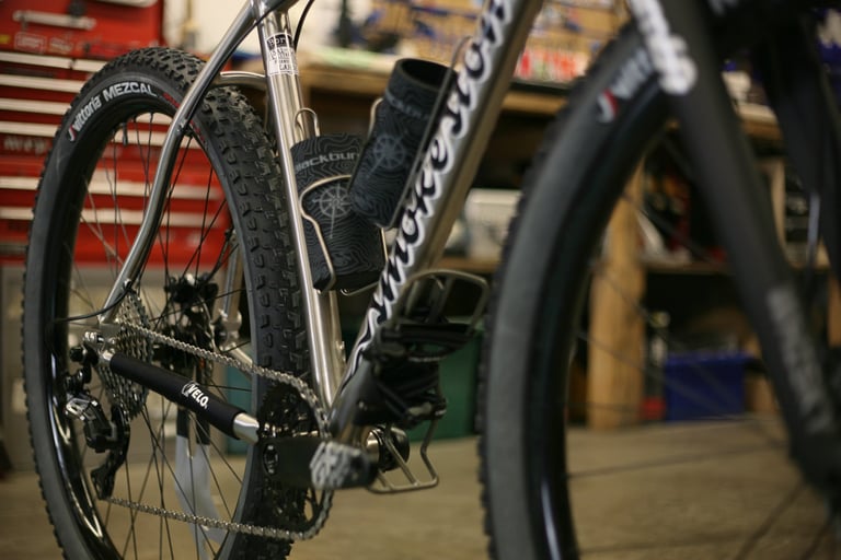 Smokestone Mr Harry frame detail showing two bottle cages inside the front triangle and a big-volume Vittoria tyre.