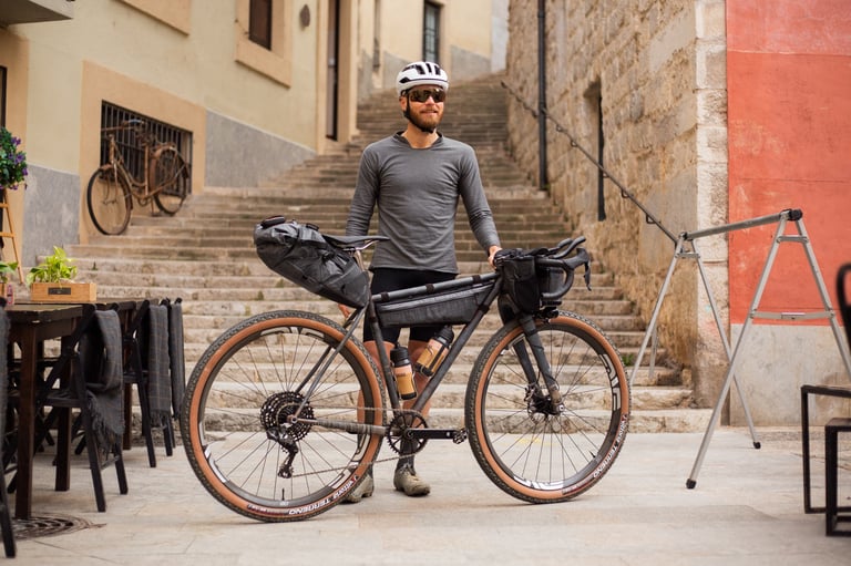 Christian Meier of The Service Course stands with the loaded Belle Cycles A.T.E.R. at the foot of stone steps in an old town.