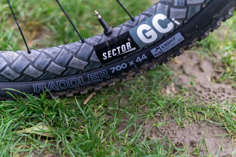WTB Raddler 700 x 44 tyre with TCS Light sidewall label and a Sector GCi sticker on the rim, on wet grass.