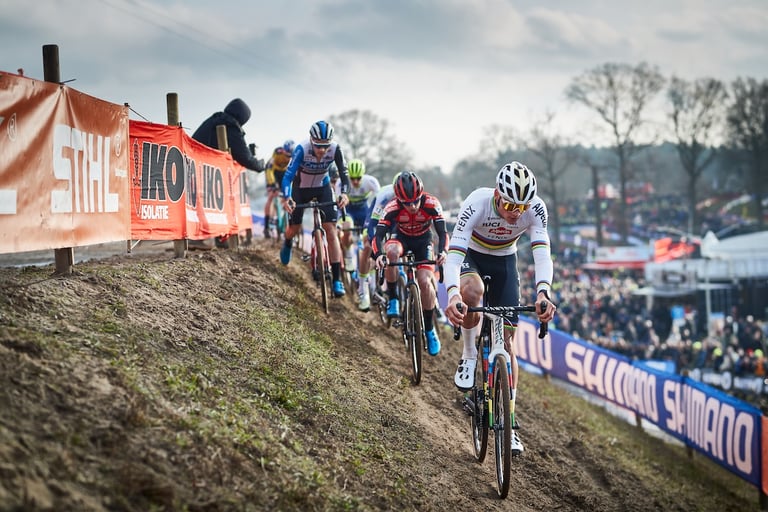 Mathieu van der Poel leads a line of riders along an off-camber bank past Stihl banners at Hoogerheide.