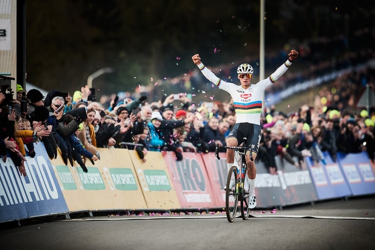 Mathieu van der Poel celebrates victory at Hoogerheide with arms raised as confetti falls and fans reach out.