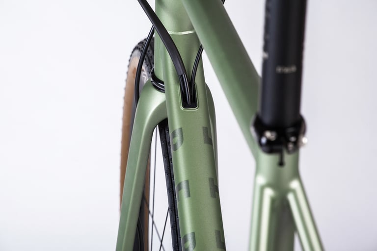 Close-up of the Verne's internal cable routing, cables entering a port in the green frame beside the tyre.