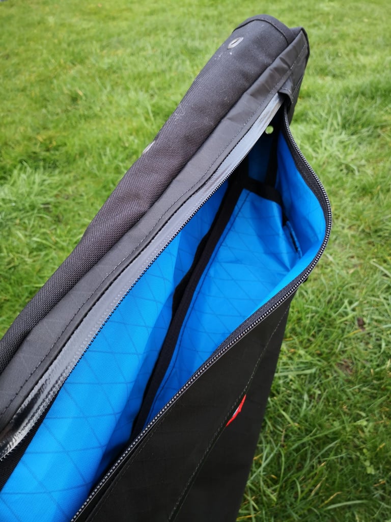 Straight Cut Design frame bag unzipped to show the blue liner of the drive-side top compartment and a bolt-hole eyelet.