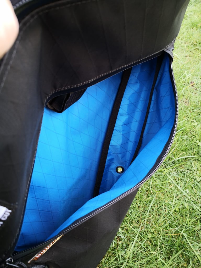 Wide-open lower compartment of the Straight Cut Design frame bag, with blue liner, dividing straps and an eyelet inside.