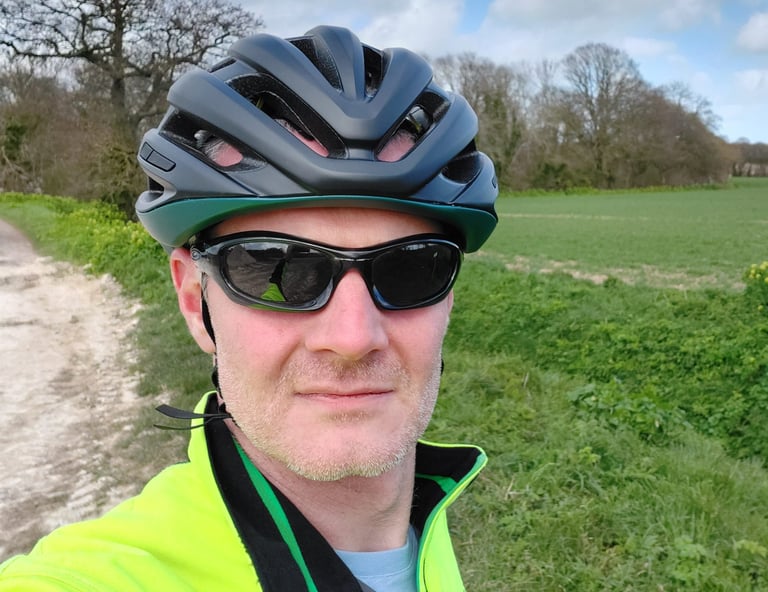 Front view of the reviewer in the Giro Agilis, daylight showing through the vents above chunky Oakley sunglasses.