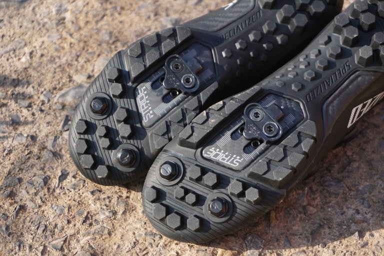 Underside of the Specialized Recon 3.0 shoes with SPD cleat plates and removable toe spike bolts in the forefoot.