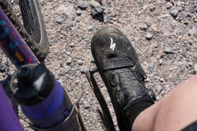 Hand holding open a Specialized Recon 3.0 shoe to show the blue mesh tongue lining and green Body Geometry insole.