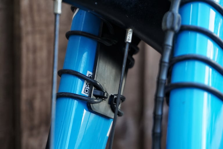 Close-up of black o-rings securing a Gravelhugger front guard to the blue fork legs, with helitape beneath.