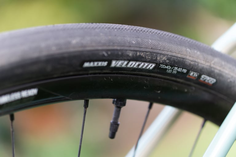 Maxxis Velocita 700x40c tyre sidewall on a tubeless-ready rim, with its near-slick centre tread.