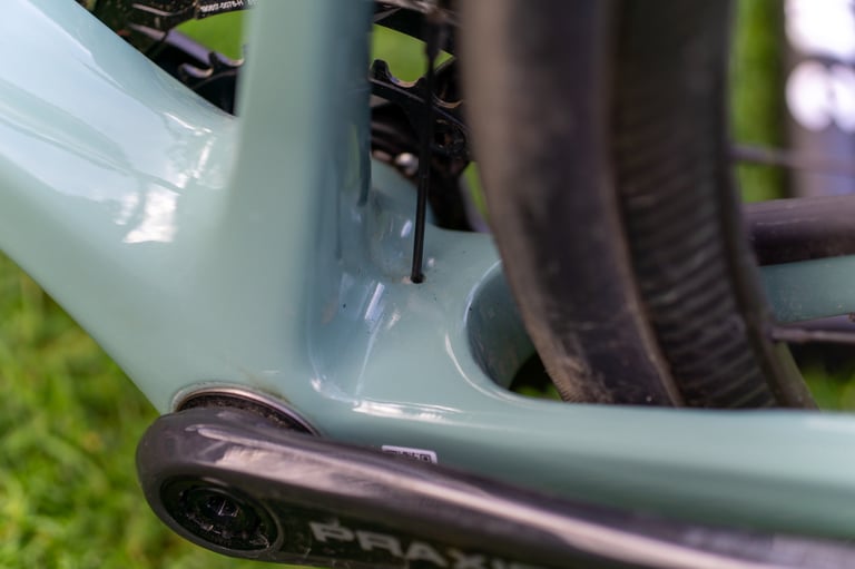 Chunky bottom bracket area of the Giant Revolt Advanced 0 frame, with Praxis crank arm and rear tyre.