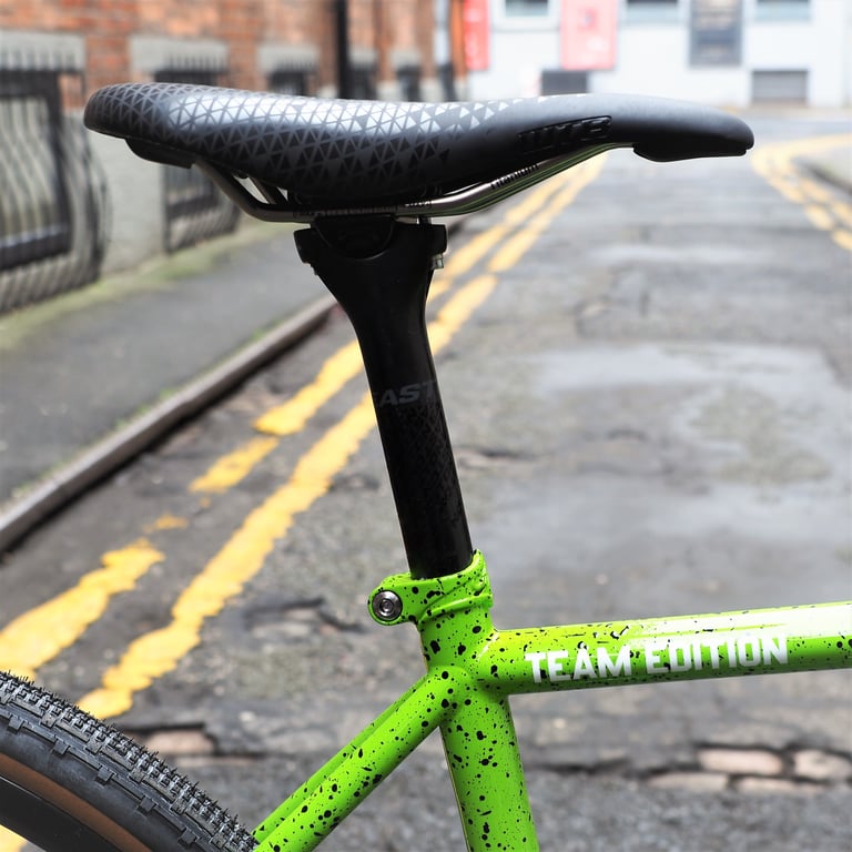 Saddle, seatpost and Team Edition lettering on the green splatter-paint All City Nature Boy frame.