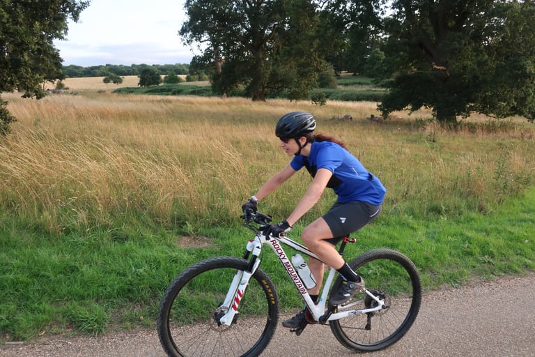 Sarah Hewitt, tester of TRR Pro Advanced Collagen, riding a Rocky Mountain hardtail along a path beside long grass.