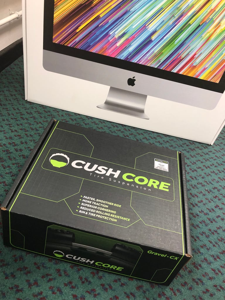 CushCore Gravel-CX box on a carpeted floor, its lid listing claimed benefits such as rim and tyre protection.