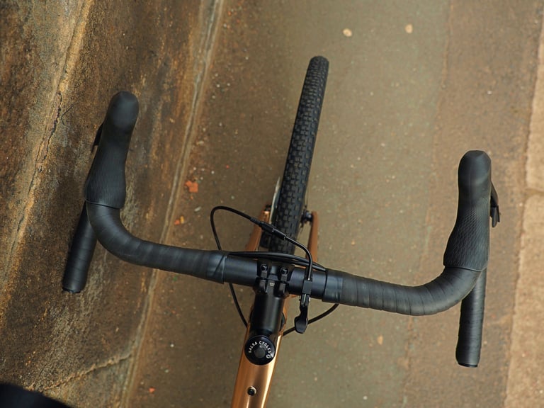 Top-down view of Salsa Cowchipper Deluxe bars, GRX levers and Salsa Cycles stem cap on the Stormchaser.