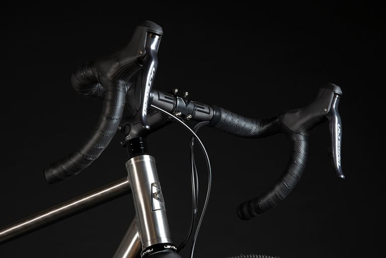 Ribble CGR Ti 44mm head tube with Ultegra shifters and a drop handlebar wrapped in textured black tape.