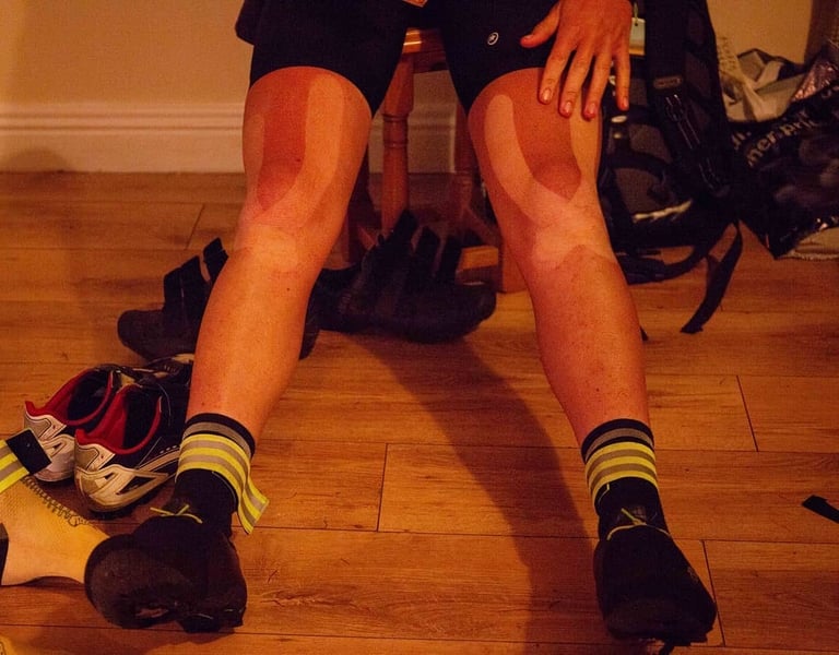 A rider's knees show pale tan lines where kinesiology tape sat after the TransAtlantic Way on a Brompton.