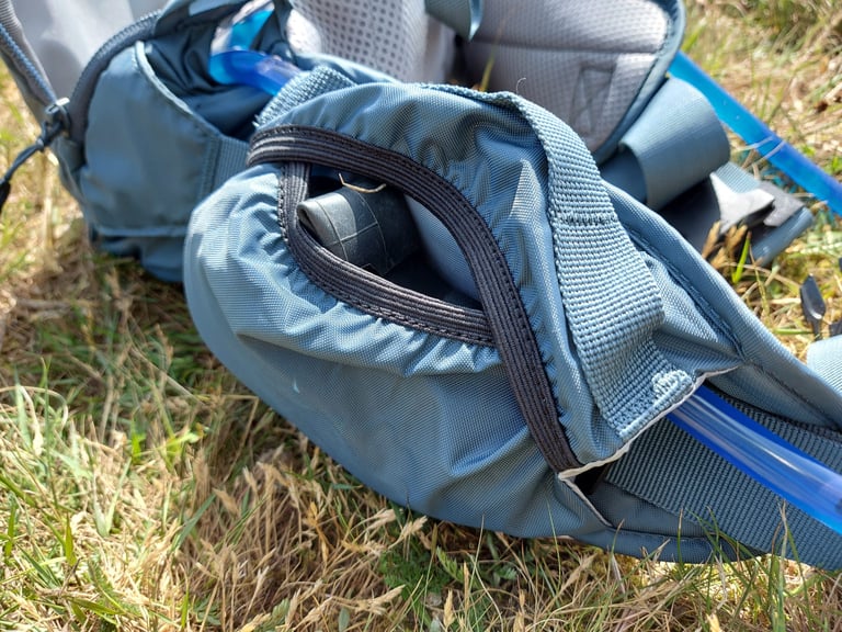 Camelbak Repack LR 4 elasticated side pocket holding an inner tube, with the hose running along the belt.