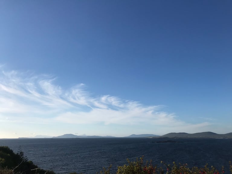 Clew Bay on Ireland's west coast under a blue sky, with distant hills across the water on the TransAtlantic Way.
