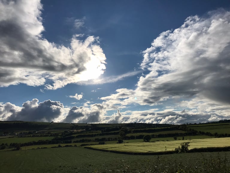 Green fields and hedgerows roll away under big clouds on day one of the TransAtlantic Way heading north from Dublin.