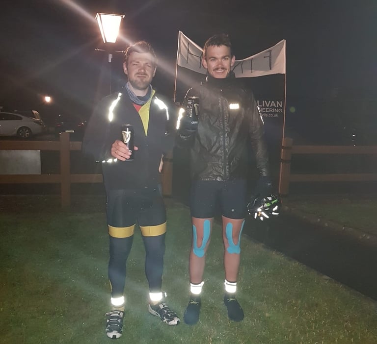 Mark Donnelly-Orr and Jack Shuttleworth hold cans of Guinness under a lamp at the TransAtlantic Way finish in Kinsale.
