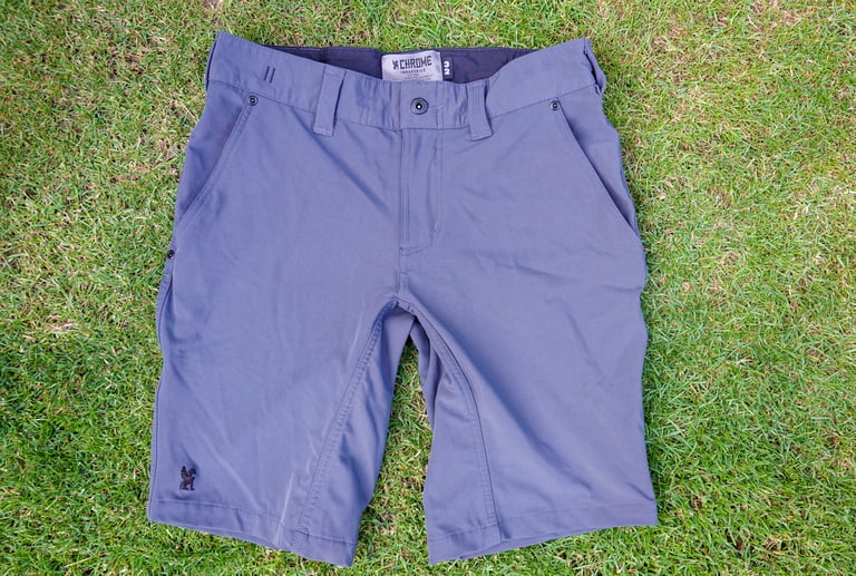 Chrome Industries Folsom Short 2.0 laid flat on grass, front view, showing belt loops, fly and side pockets.