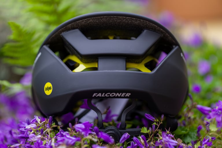 Rear of the Falconer II helmet, with MIPS badge, yellow liner showing through the vents and the adjuster dial below.