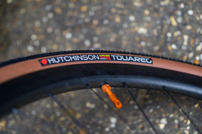 Hutchinson Touareg 700x40 tanwall tyre with Hard Skin sidewall grid, mounted on a wheel with an orange valve.