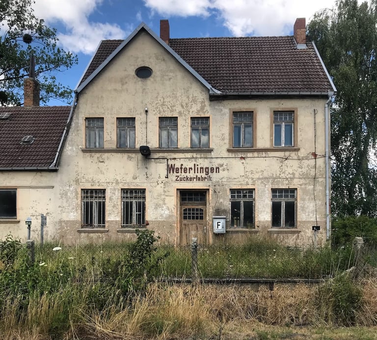 Derelict Weferlingen Zuckerfabrik railway station with peeling plaster, seen on the Grenzsteintrophy route.