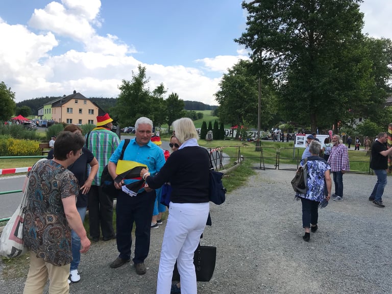 Crowd with German flags gathered on a village road at an anti-Nazi rally near the former inner German border.