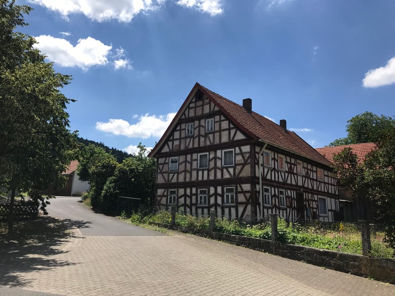 Half-timbered house beside a quiet village lane in Germany, seen on the Grenzsteintrophy route.