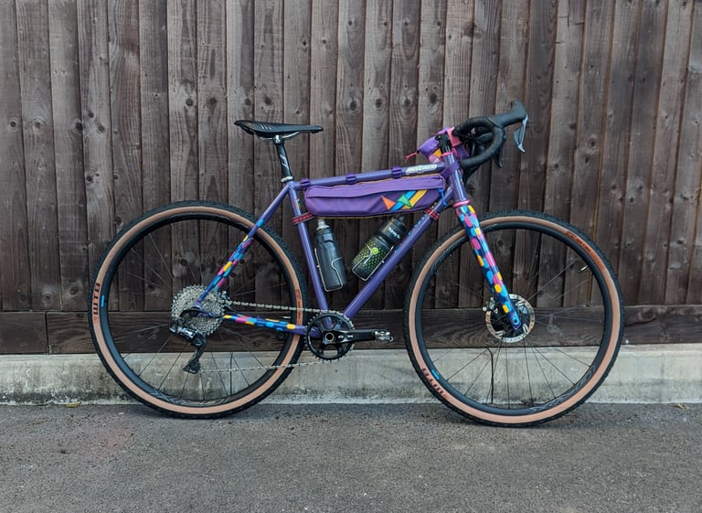 Katherine's purple gravel bike with confetti-pattern paint, frame bag and two bottles, ready for the Bristol Dirty Kanzelled.