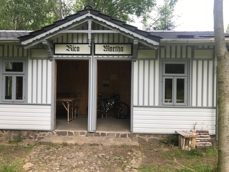 Emma's Kinesis mountain bike sheltering in a restored wooden pavilion at the former Jungborn naturopath spa, Harz.