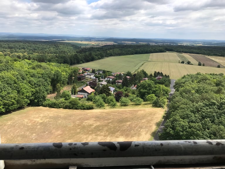 View from the Zimmerau viewing platform over fields, forest and a village on the former inner German border.