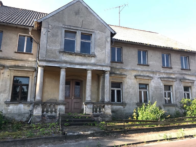 Crumbling 1908 house with a columned porch in Rustenbeck, one of the forgotten former East German border towns.