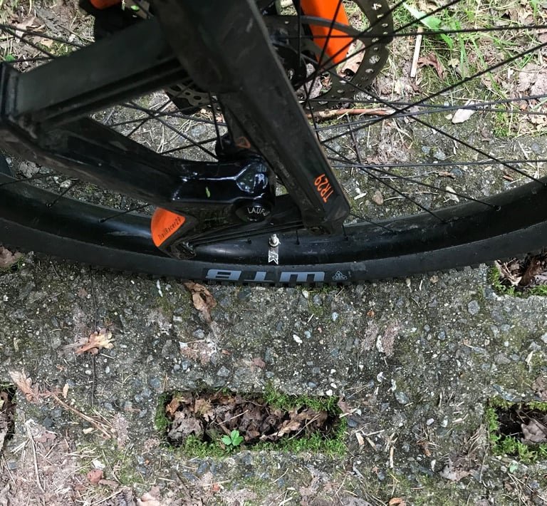 WTB 2.8in tyre and Lauf TrailRacer29 fork beside a hole in a concrete Panzerweg plate.