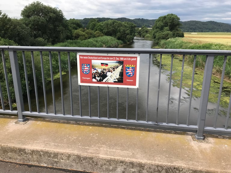 Sign on a river bridge marking where Thuringia met Hesse and Germany was divided until December 1989.