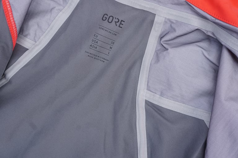 Inside of the GORE Infinium Hybrid Jacket showing taped seams and the size label, EU 38.