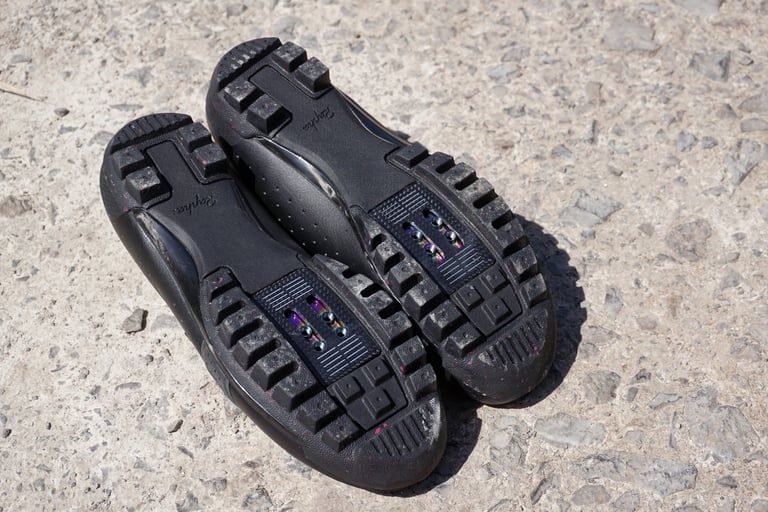 Underside of the Rapha Explore Shoes showing the lugged rubber sole and oil-slick titanium cleat plate.