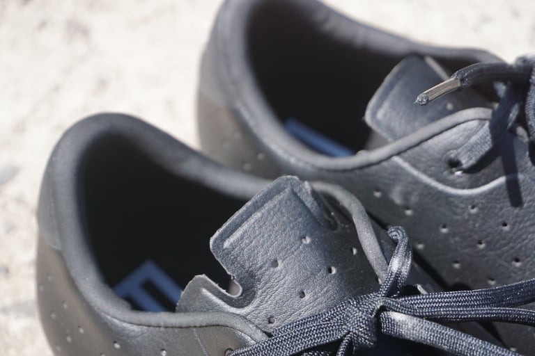 Inside the heel cups and tongues of the Rapha Explore Shoes, showing the perforated upper and lace ends.