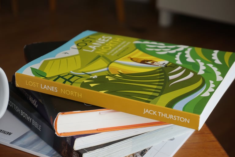 Lost Lanes North guidebook, spine showing Jack Thurston's name, stacked on other books on a table.